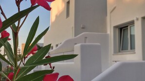 Ein modernes Gebäude mit weißen Wänden und einem flachen Dach, ausgestattet mit einem Balkon und Geländer.