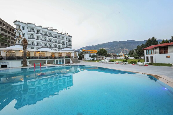 Alberca al aire libre, sombrillas en la alberca y camastros