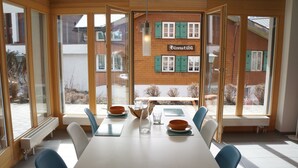 A conference room with a large table, chairs, and a view of a building with a sign reading "Bärenstübli". - Chalet Bella Vista 1 (Lauterbrunnen)