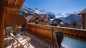 A wooden balcony with a view of snow-capped mountains. - Chalet Aquila 7 Penthouse (Lauterbrunnen)