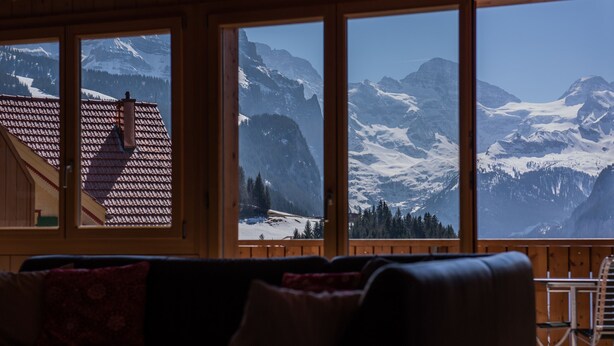 A room with a view of snow-covered mountains through large windows. - Chalet Aquila 7 Penthouse (Lauterbrunnen)