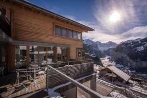 A wooden chalet with a balcony overlooking a snowy mountain valley. - Chalet Dillon (Lauterbrunnen)