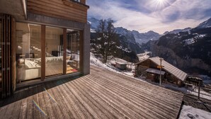 A wooden building with large glass windows overlooking a snowy mountain landscape. - Chalet Dillon (Lauterbrunnen)