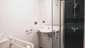 Ein modernes Badezimmer mit Toilette, Waschbecken und einer Duschkabine.