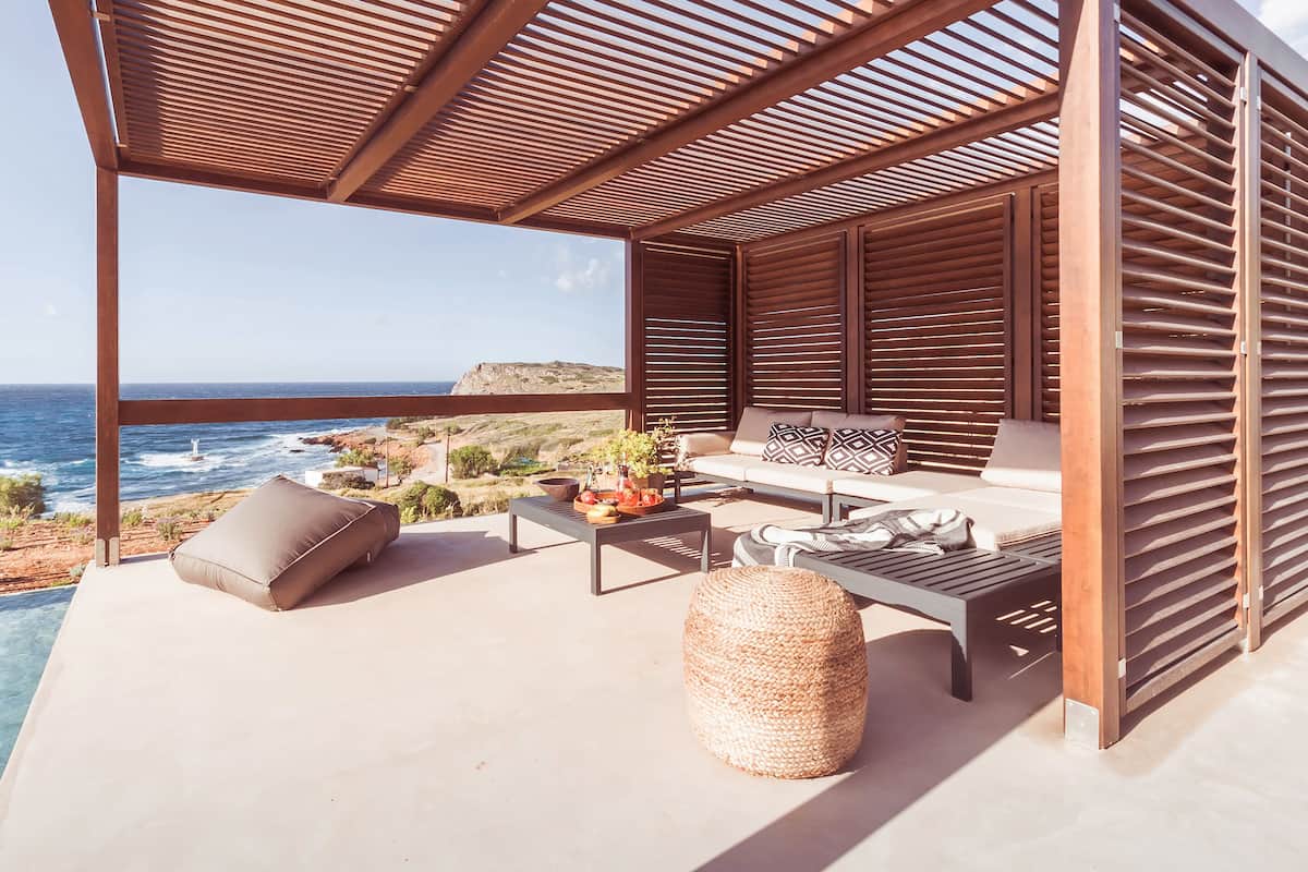 Un área de estar moderna al aire libre con vista al océano.