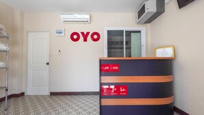 Un espace d’accueil comprenant un comptoir de réception, une porte et un climatiseur fixé au mur.