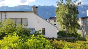 A building with a sloped roof, a chimney, and a window with shutters. - At home in the love nest (Innsbruck)