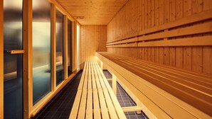 Un sauna avec des bancs en bois et des portes en verre.