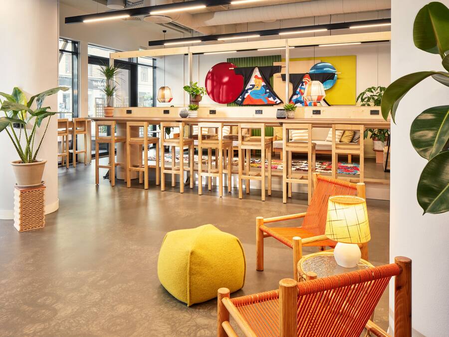 A modern interior with wooden furniture, potted plants, and colorful artwork.