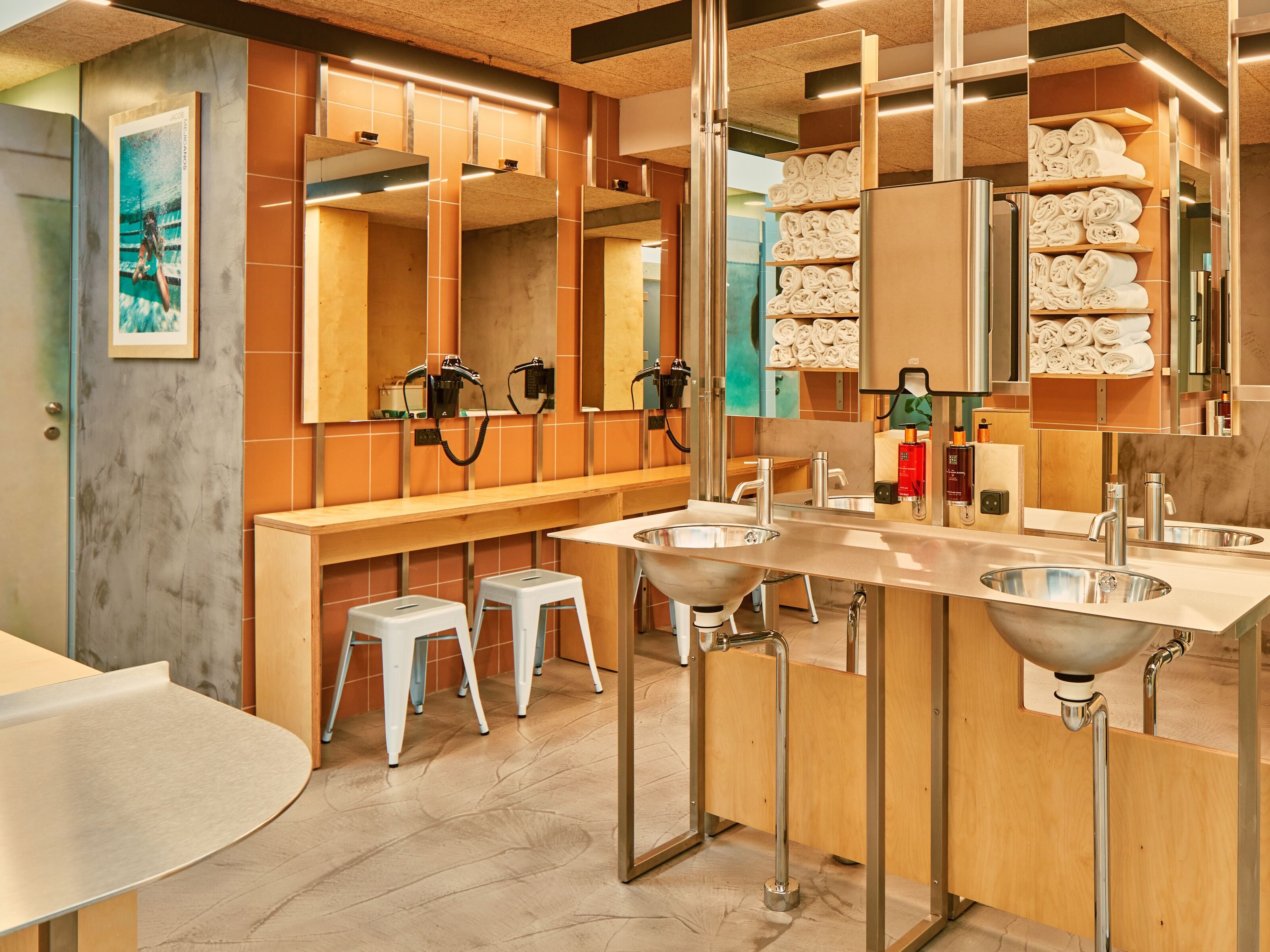 A modern bathroom with a large mirror, two sinks, and a towel rack.