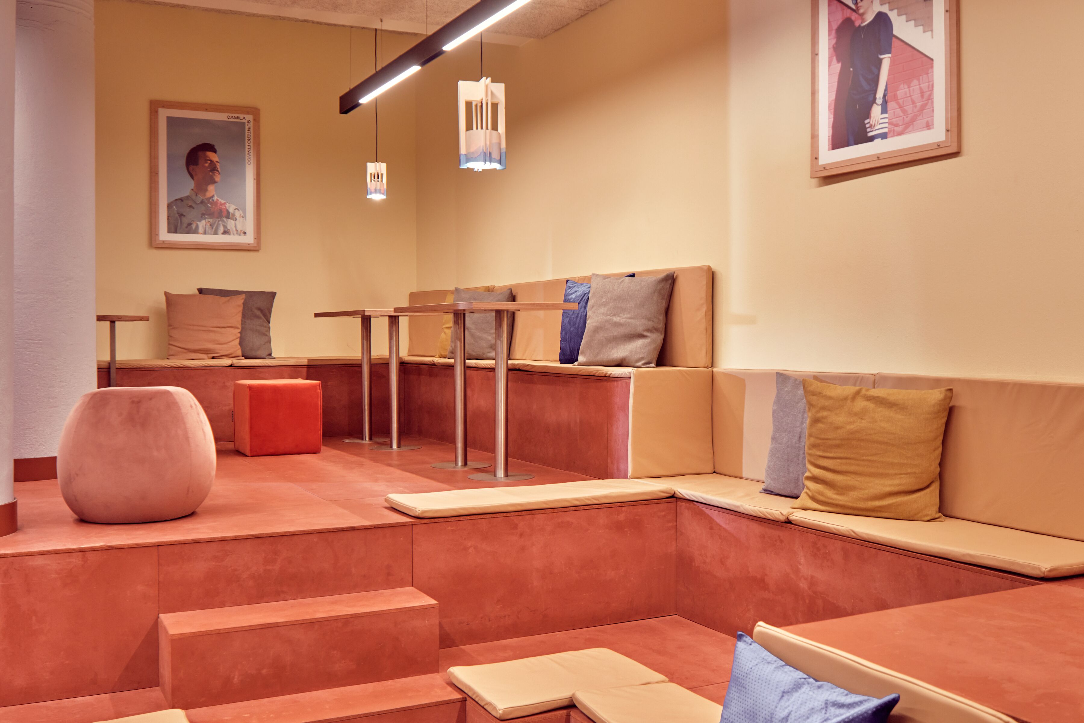 A modern waiting area with cushioned seating, a small table, and pendant lighting.