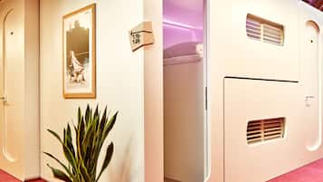 Una habitación de hotel moderna con un espejo grande, una planta en maceta y un cuadro en la pared.