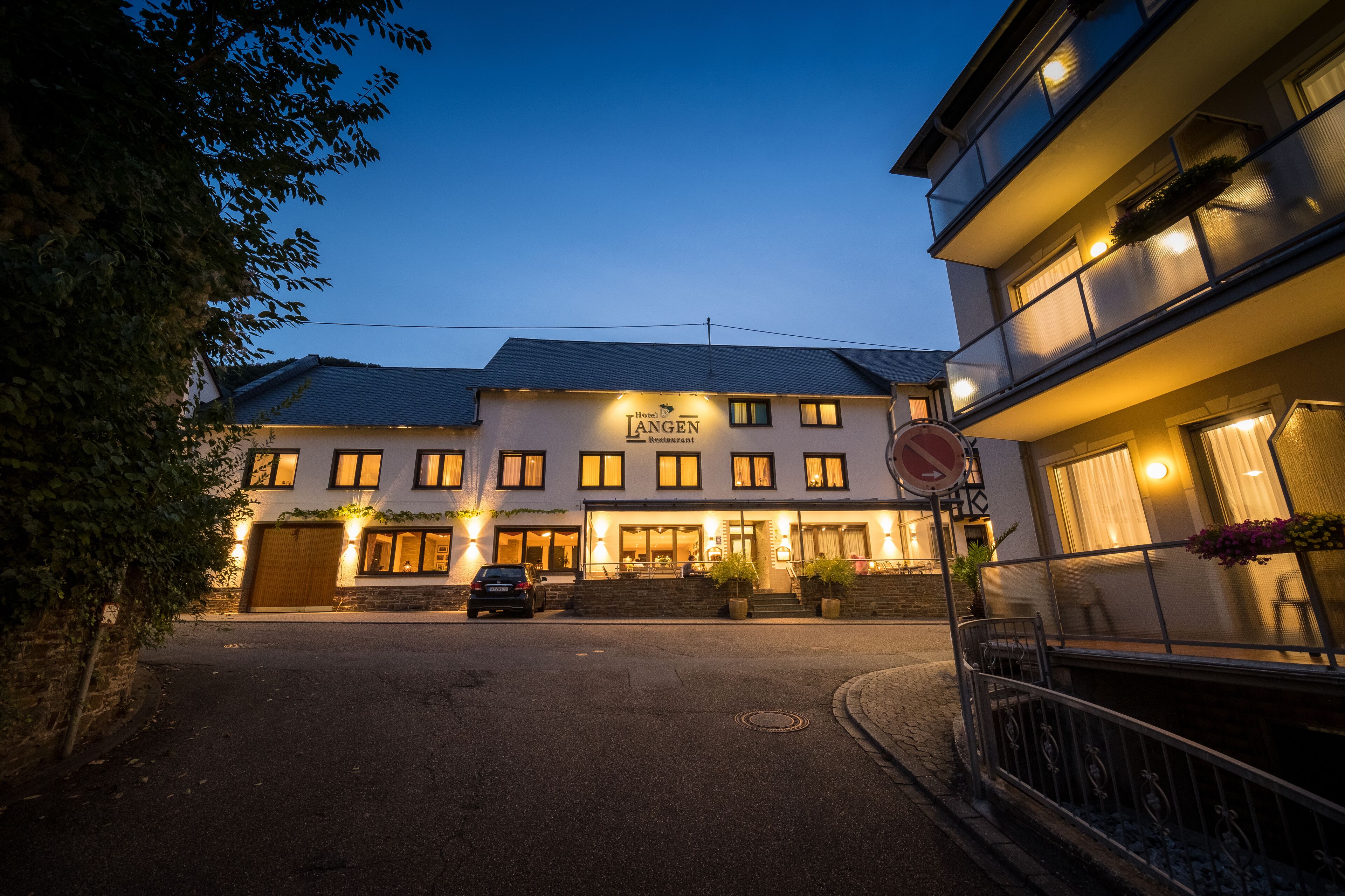 A hotel with a sign reading "Hotel Langen Restaurant" at dusk.