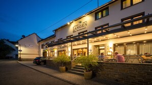 A hotel named 'Hotel Langen Restaurant' with outdoor seating and a car parked in front. - Hotel Langen (Loef)