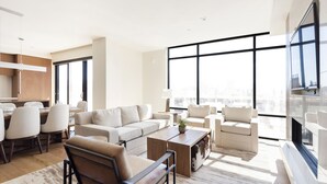 Una sala de estar moderna con un sofá, sillas, una mesa de centro y un comedor con sillas y una mesa.