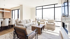 Ein modernes Wohnzimmer mit großem Fenster, Essbereich und Küche.