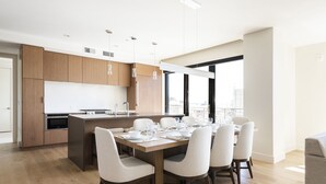 Eine moderne Küche mit Holzausstattung, einem eingebauten Ofen und einem Essbereich mit großem Tisch und Stühlen.