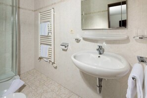Enjoy a refreshing shower in this bathroom featuring a glass enclosure, a sink with a chrome faucet, and a mirror.