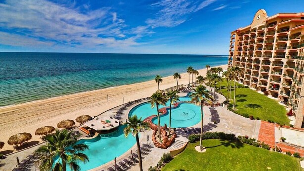 A resort with a pool, beach, and ocean view.