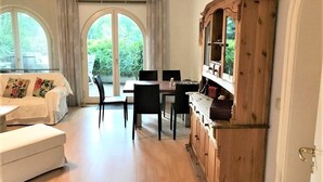 Et spiseområde med et træskab, en hvid sofa og et bord med stole.