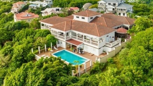 A large, multi-story house with a swimming pool, surrounded by lush greenery and a mountainous backdrop. - Beautiful supersize villa perfect for larger families and groups. Sleeps 22 (Cap Estate)