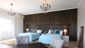 A hotel room with two beds, a dining table, and a chandelier. - Beautiful supersize villa perfect for larger families and groups. Sleeps 22 (Cap Estate)