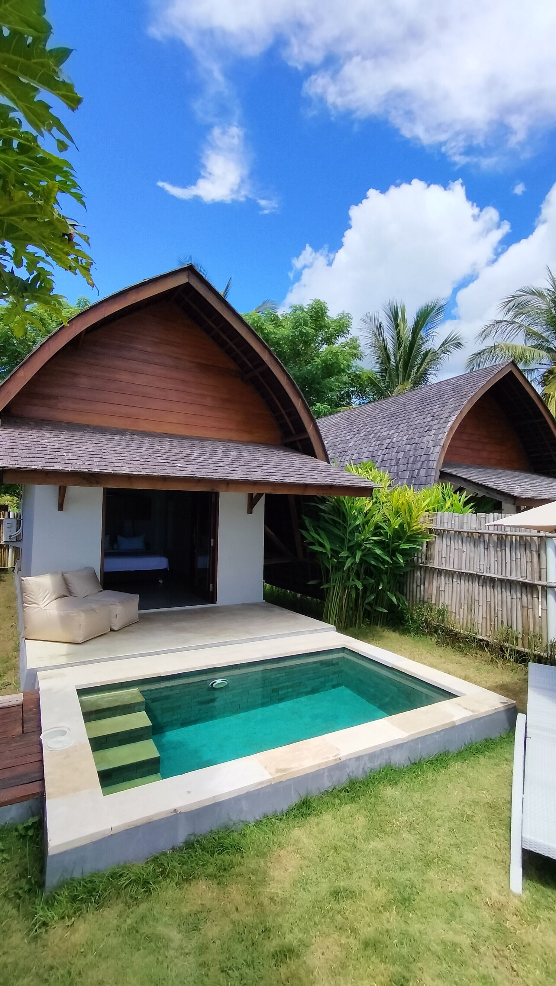 A two-story house with a swimming pool, a covered patio, and a fenced garden area.