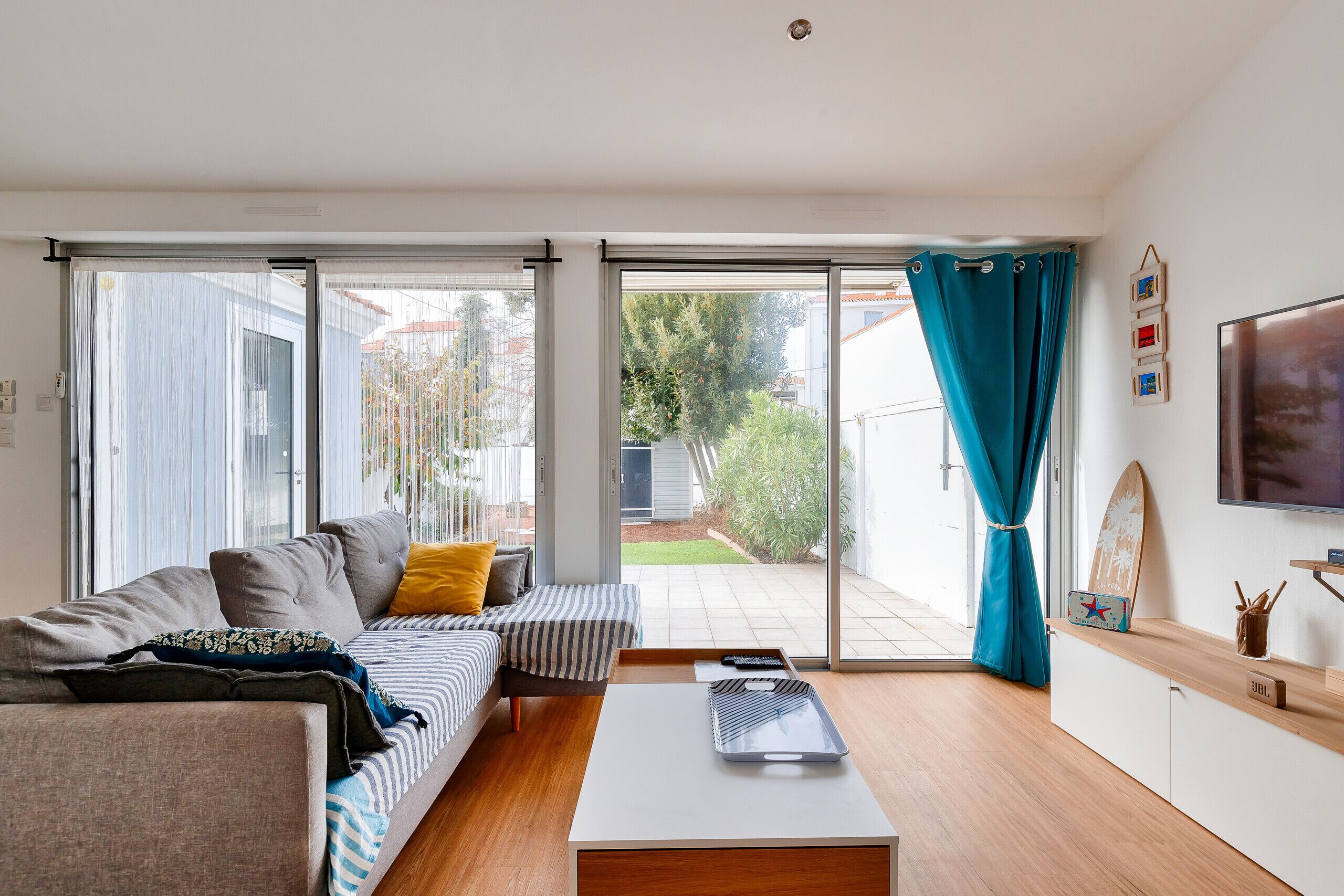 Un salon moderne avec un canapé, une table basse et un téléviseur.