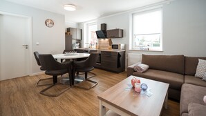Un appartement moderne comprenant un coin repas, une cuisine et un espace de vie.
