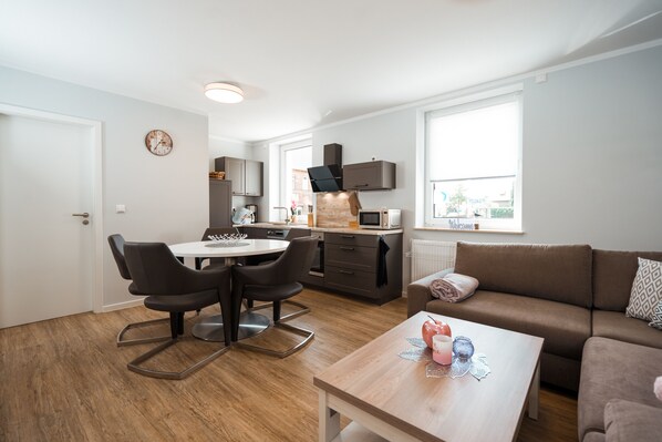 Eine moderne Wohnung mit Essbereich, Küche und Wohnraum.