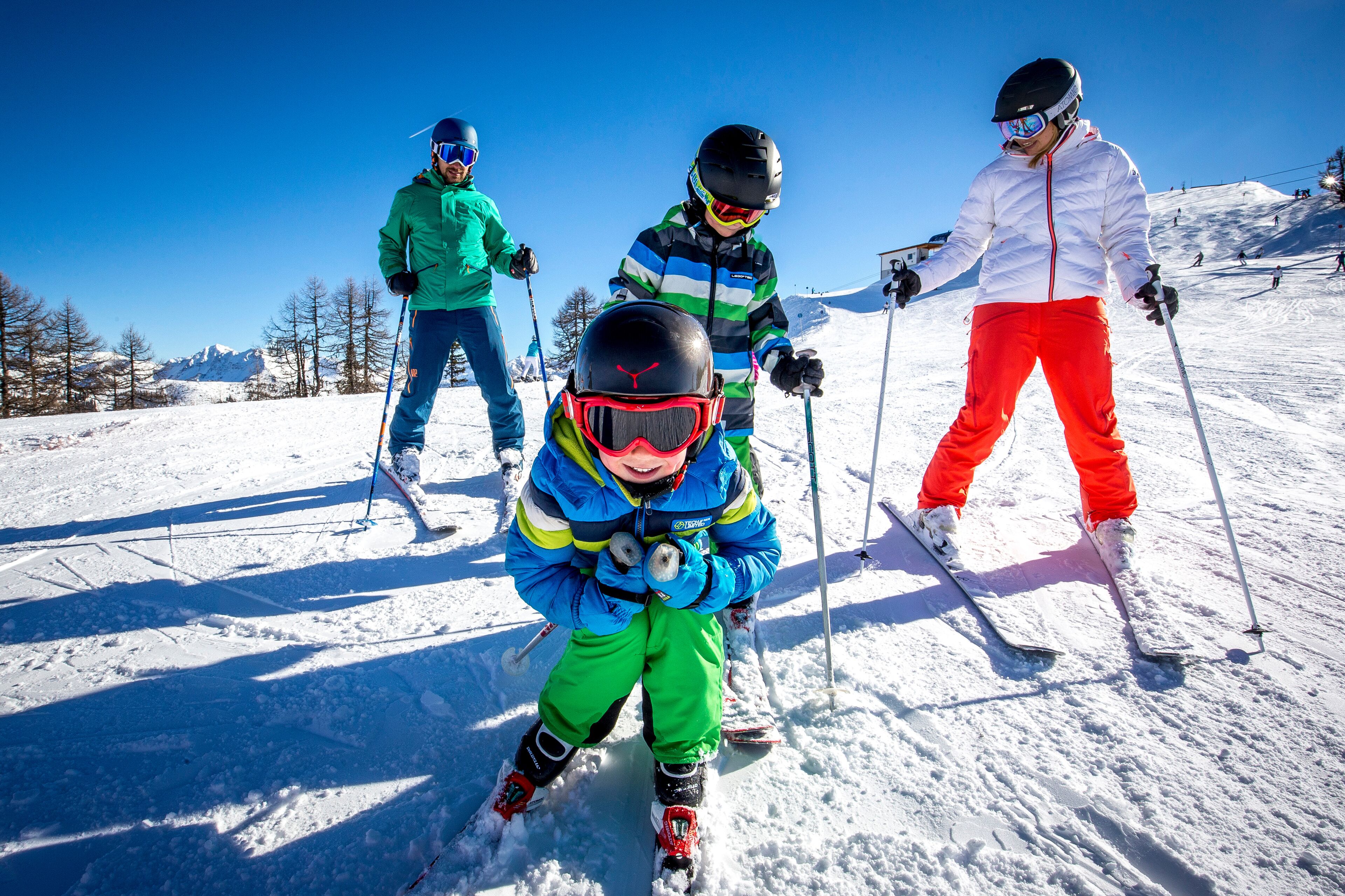 A group of skiers on a snowy slope with clear skies.