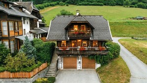 A two-story house with a balcony, a garage, and a driveway.