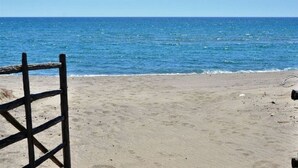 Una playa con una valla de madera y una vista despejada del océano.