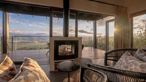A modern outdoor seating area with wicker furniture and a wood-burning stove.