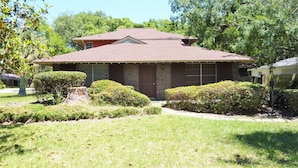 A single-story house with a brick facade, a front porch, and a well-maintained lawn.