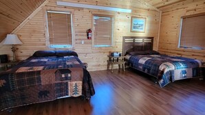 Una cabaña acogedora con dos camas, paredes de madera y techo inclinado.