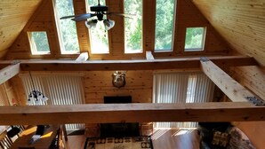 Un loft espacioso con techos altos, vigas de madera y ventanas grandes.