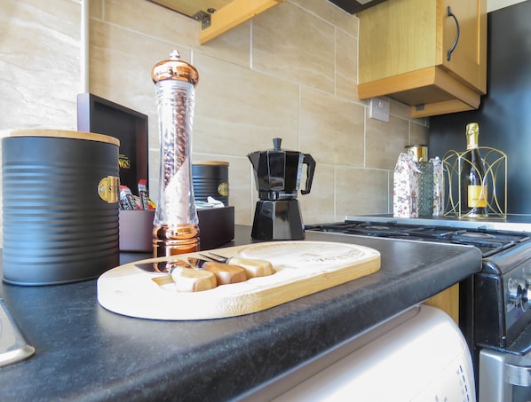 Enjoy cooking in this well-equipped kitchen with a stove, coffee maker, and spice grinder.
