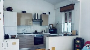 Una cocina moderna con comedor, que incluye una mesa y sillas de madera, un microondas y una estufa.