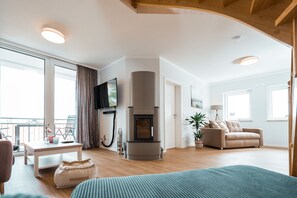 Una sala de estar amplia con chimenea, un sofá, una mesa de centro y un televisor.