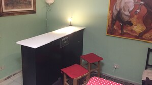 A reception desk with a sign indicating it's the reception area, two red chairs, a framed painting, and a lamp. - 6 Keys (Pisa)