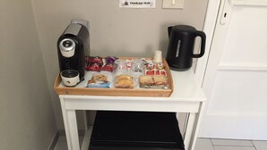 A kitchenette with a coffee maker, a kettle, a tray with snacks, and a small refrigerator. - 6 Keys (Pisa)