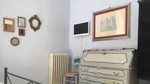 A room with a radiator, a dresser, and various framed items on the wall. - 6 Keys (Pisa)