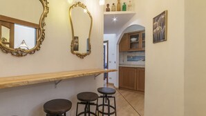 A kitchen with wooden cabinets, a countertop, and a hanging light fixture. - GuestHost - The quiet apartment is located on the first floor of a characteristic period building with a lift (NOT suitable for the disabled).In 55 square meters of space it accommodates 4 people, with two bedrooms.Located in the heart of the Prati distr (Roma)