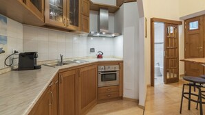 A kitchen with wooden cabinets, a stainless steel range hood, a built-in oven, and a coffee maker. - GuestHost - The quiet apartment is located on the first floor of a characteristic period building with a lift (NOT suitable for the disabled).In 55 square meters of space it accommodates 4 people, with two bedrooms.Located in the heart of the Prati distr (Roma)