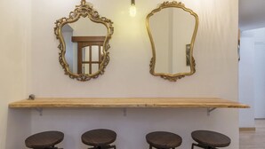A bar area with two ornate mirrors, a wooden bar counter, and four stools. - GuestHost - The quiet apartment is located on the first floor of a characteristic period building with a lift (NOT suitable for the disabled).In 55 square meters of space it accommodates 4 people, with two bedrooms.Located in the heart of the Prati distr (Roma)