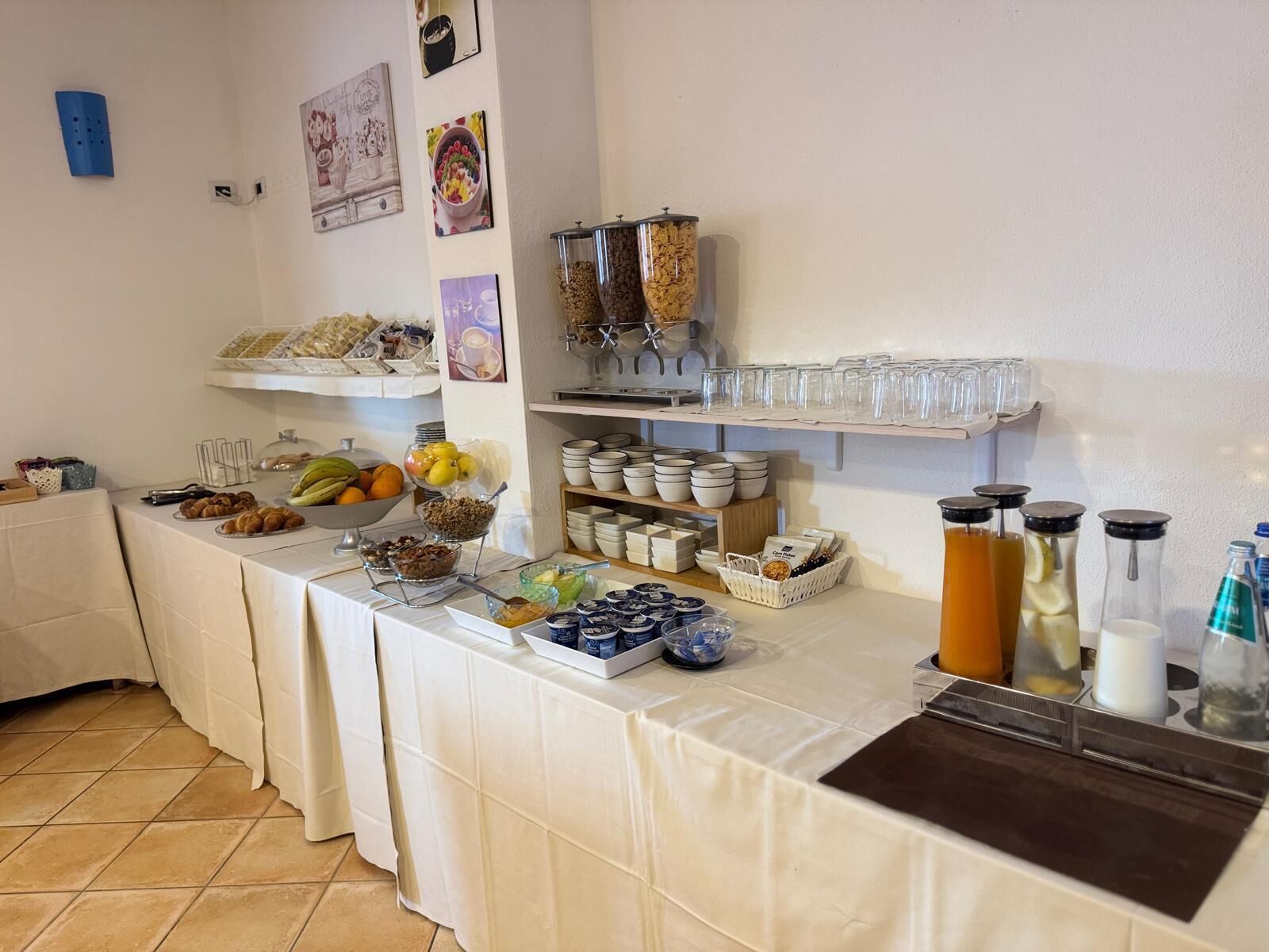 Una mesa con una variedad de alimentos, platos y recipientes en estilo bufé.