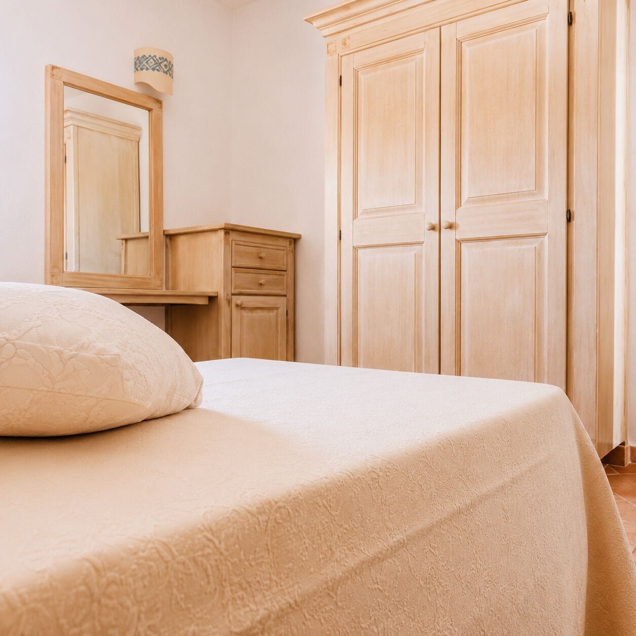 Une chambre à coucher avec un lit, une commode et une armoire.