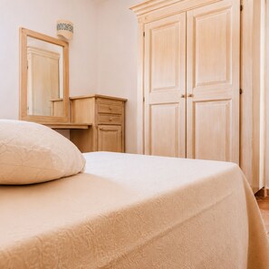 Une chambre à coucher avec un lit, une commode et une armoire.