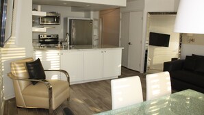 A modern living space with a kitchen, dining area, and seating.